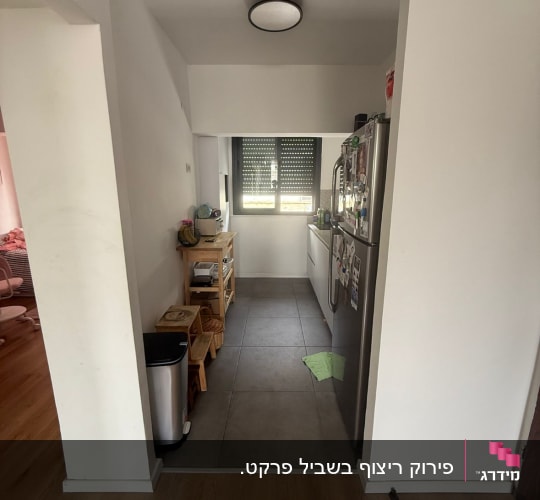 מטבח קטן עם רצפת עץ וכלי מטבח על מדפים